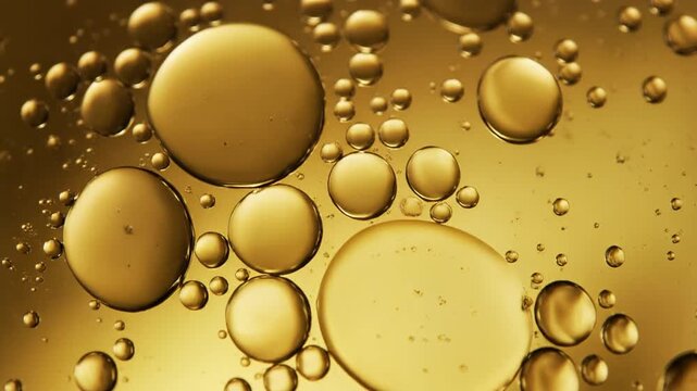 Golden Serum Drop and Oil Bubbles Floating in Liquid Macro Background