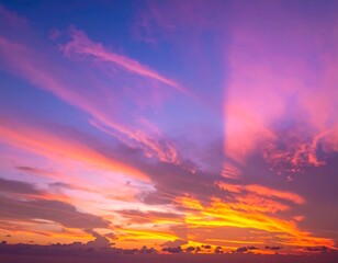 Obraz premium Vivid sunset featuring a captivating gradient of warm and cool colors. Streaks of light pierce through the clouds creating dramatic views