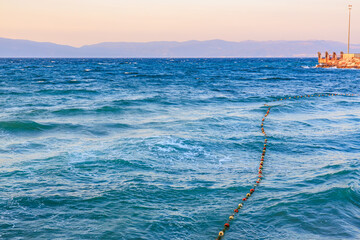 Tranquil ocean view with floating buoys at sunset