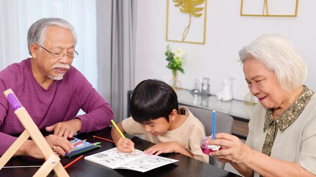 Grandparents Helping Grandchild With Homework at Kitchen Table