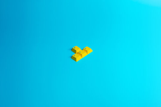 Minimal yellow keyboard keys on blue background with copy space