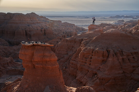 Small silhouette of photographer in desert landscape with rock formations canyon