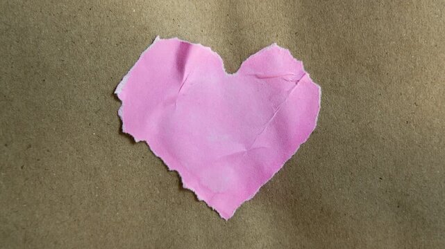 Random texture of pink heart shape paper on brown paper