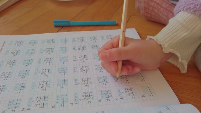 A young student huffs in frustration, erasing a mistake for the third time. Tears well up as complex math equations remain unsolved. This raw footage highlights the reality of learning hurdles.