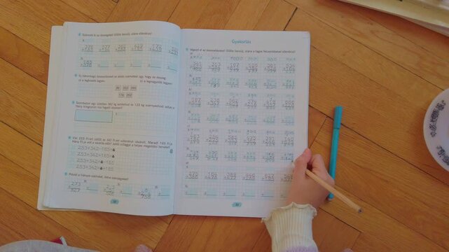 A child engaged in independent math study at home. This high-quality footage represents the modern shift toward personalized learning, distance education, and the comfort of a home-school environment.