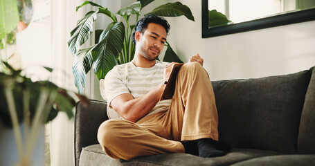 Man, journal and writing on sofa in house, daily reflection or idea notes to relax for creativity. Person, notebook for planning or sketching with agenda in diary, to do list or goal setting in home