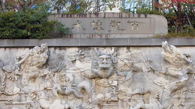 Stone relief carving: Japanese dragons emerge from stone wall in Japan