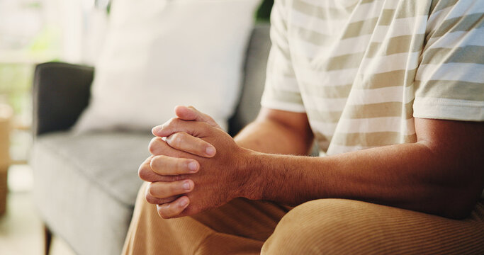 Hands, trauma and man on sofa in home with stress, phobia or stimming for panic attack with mental health. Overthink, crisis and male person in living room with anxiety, fear or trigger in house.