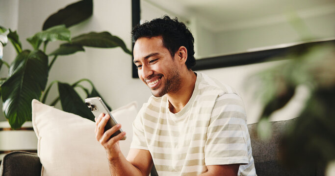 Home, cellphone and happy man on couch, typing and social media with connection. Email notification, mobile user or person with smartphone, internet or digital app with online reading or website info