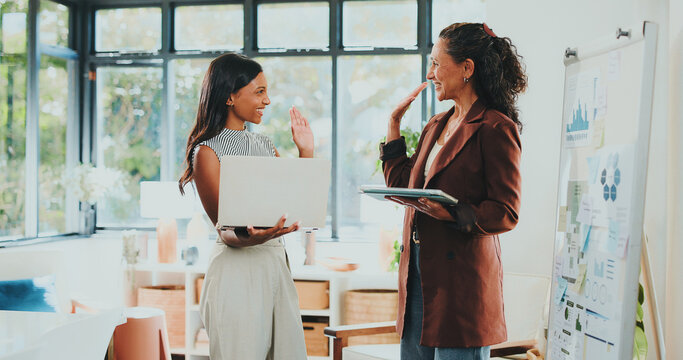 Creative women, high five and tech for designer agency in office for internship or project management. App, meeting and celebration with woman, mentor and coaching for training conversation or update