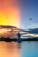 Twilight of Buddha Statue with Split Sky in water (Phra Chom Nam) in Khao Rakham Reservoir at Trat Province of Thailand