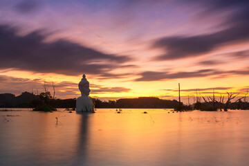 Twilight of Buddha Statue with Split Sky in water (Phra Chom Nam) in Khao Rakham Reservoir at Trat Province of Thailand