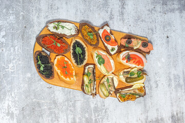 An assortment of gourmet open-faced sandwiches with various toppings on a textured background, perfect for culinary and food presentations.