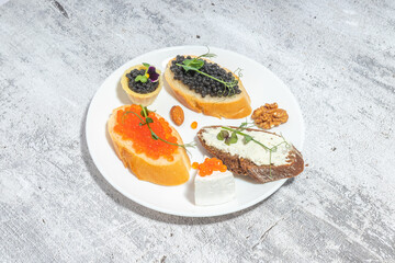 An elegant plate featuring assorted gourmet appetizers with caviar, cream cheese, and various garnishes on a rustic background.
