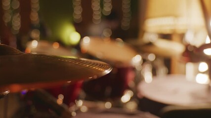 Detailed view of a drum set with shimmering bokeh lights, creating a warm and rhythmic musical atmosphere.