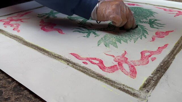 Frottage street art: Rubbing dragon drain cover with charcoal on paper