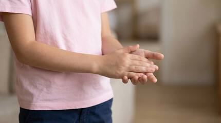 Close-up of a child rubbing hands together, promoting hand hygiene, cleanliness, and disease prevention. Essential for health and safety