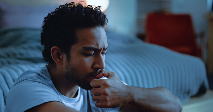 Night, lonely and man thinking with anxiety, mental health or insomnia from sad memories in bedroom. Late, contemplation and anxious person with grief, worry and sleepless from biting nails in house.