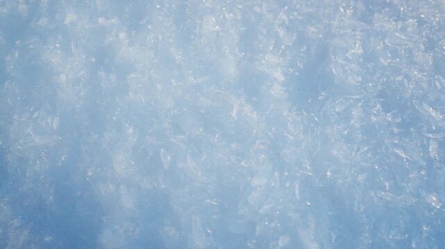 Rotating close up of snow crystals creating abstract winter texture