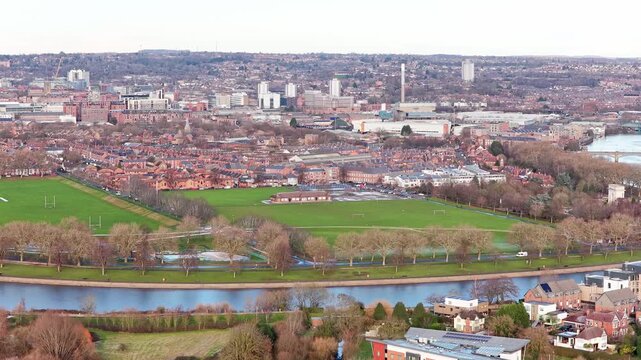 Lady Bay Playing Fields' multiple grass pitches along River Trent in West Bridgford, revealing sports facilities, riverside path, Lady Bay Bridge, and Nottingham city centre skyline, static shot.