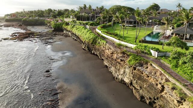 Bali cliff beach with a Hindu temple at Pantai Mengening beach/cliff side with Pura Gede Luhur Batu Ngaus temple located on the small peninsula off the cliffs from the main road. 