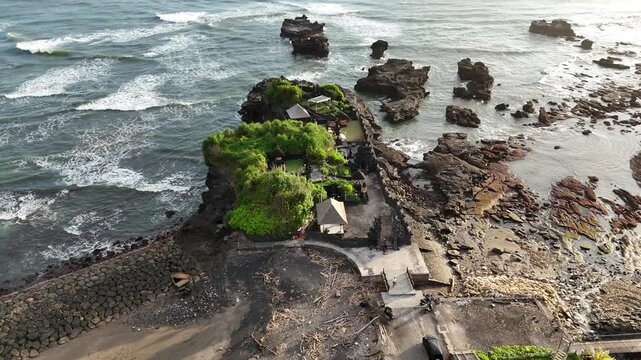 Bali cliff beach with a Hindu temple at Pantai Mengening beach/cliff side with Pura Gede Luhur Batu Ngaus temple located on the small peninsula off the cliffs from the main road. 
