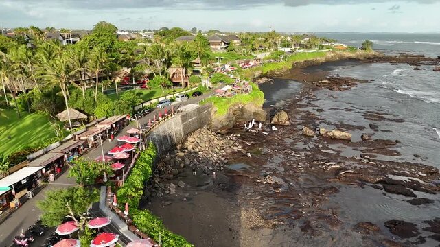 Bali cliff beach with a Hindu temple at Pantai Mengening beach/cliff side with Pura Gede Luhur Batu Ngaus temple located on the small peninsula off the cliffs from the main road. 