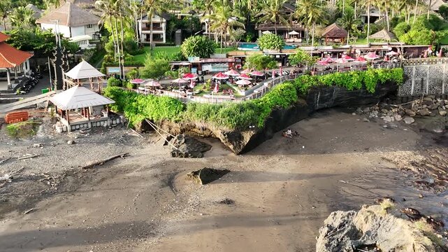 Bali cliff beach with a Hindu temple at Pantai Mengening beach/cliff side with Pura Gede Luhur Batu Ngaus temple located on the small peninsula off the cliffs from the main road. 