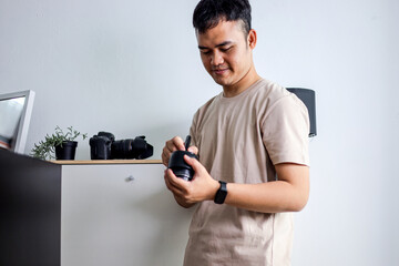 Young Photographer Examining Camera Lens in Modern Workspace