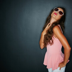Woman, pout and sunglasses in studio, confidence and lipstick on dark background. Person, playful...
