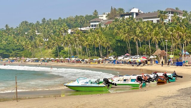 Speed Boats Lined Along Kovalam Beach with Palm Trees and Tourists