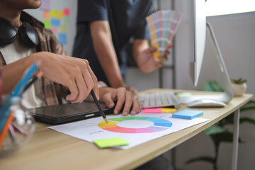 Two Young Asian Male Designers Discussing Color Selection