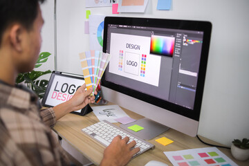 Creative Professional Holding Color Fan Decks, Comparing Shades for Logo Design Project