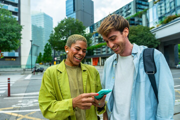 Diverse colleagues laughing checking smartphone on city street