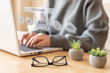 Person working on a laptop with a digital overlay showing outlook and 2026 icons, representing foresight and strategic planning for future business and financial growth