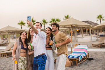 Cheerful friends taking selfie, enjoying beach party during summer vacation