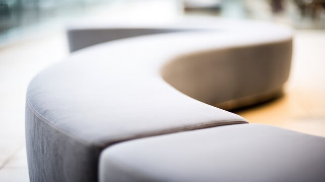 Minimal curved upholstered seating forming a flowing arc against a soft neutral backdrop. real-estate listings.