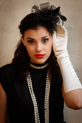 A woman wearing a black dress and a pearl necklace