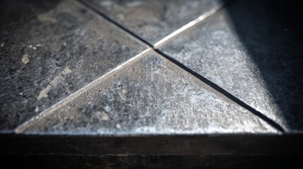 Close-up of laser-etched geometric pattern on a textured dark gunmetal surface, showing intricate details and industrial design elements.