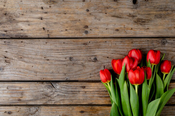 Overhead view of fresh red tulips on wooden table, copy space