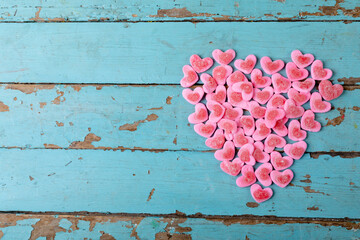 Directly above shot of heart shaped pink candies arranged on wooden table, copy space