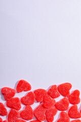 Overhead view of heart shaped red candies on white background, copy space