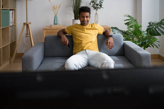 Man relaxing on sofa watching television at home living room