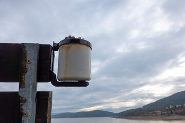 Cigarette butts in a metal ashtray on a bench in nature