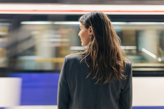 Businesswoman in business attire waiting on Madrid metro platform