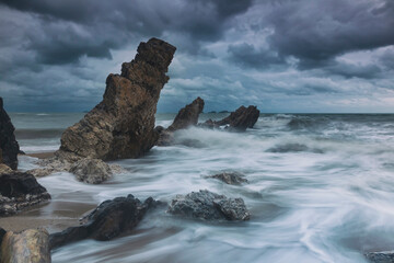 Stormy seascape with crashing waves and jagged rocks on the dramatic sky in eastern of Thailand