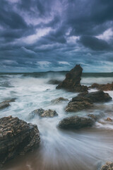 Stormy seascape with crashing waves and jagged rocks on the dramatic sky in eastern of Thailand