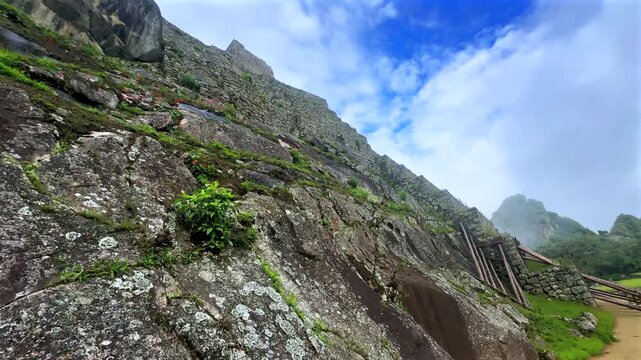 Morning foggy sunrise Inca trail Machu Picchu stonework ruins tourist circuit landscape sunny fog clouds Peruvian Andes Peru Per&uacute; historic Inca Sanctuary Temple rainy season lush green jungle left pan