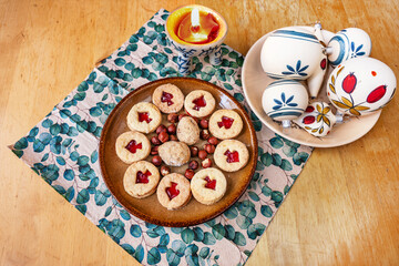 Linzer cookie and nut on plate, napkin, Christmas ball and candle.