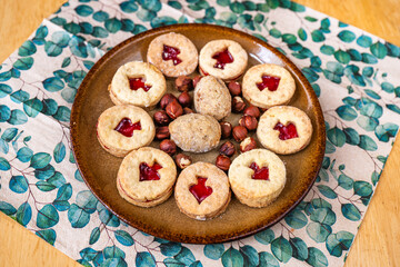 Christmas Linzer cookie and nut on plate, napkin on wooden table